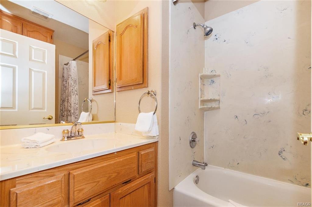 613 Riverside Avenue Sugarloaf, CA 92386 - Photo 14 of 27 a bathroom with a granite countertop sink a mirror and a bathtub