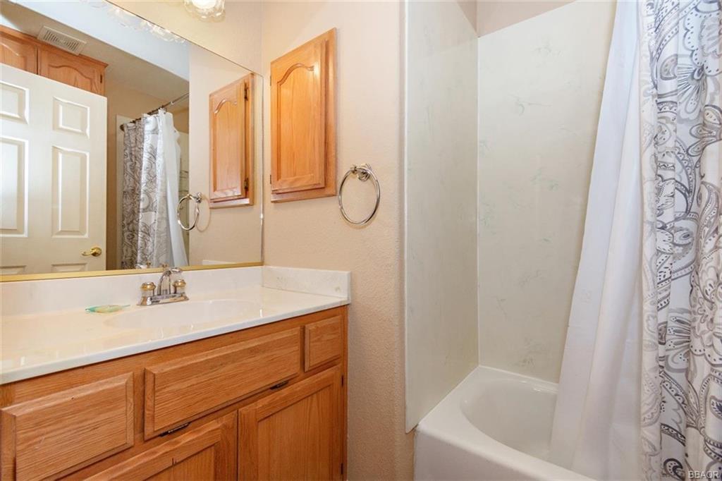613 Riverside Avenue Sugarloaf, CA 92386 - Photo 17 of 27 a bathroom with a granite countertop sink a mirror and a bathtub