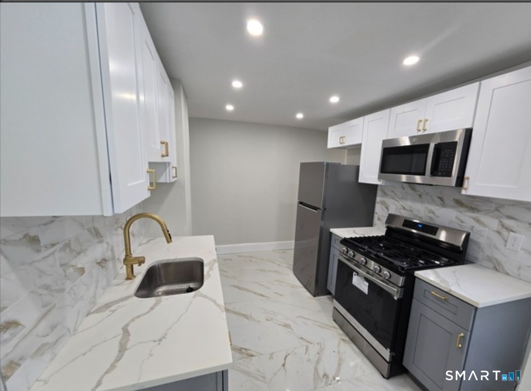80 Dickerman Street New Haven, CT 06511 - Photo 1 of 12 a kitchen with kitchen island stainless steel appliances a sink a stove a microwave a sink and cabinets