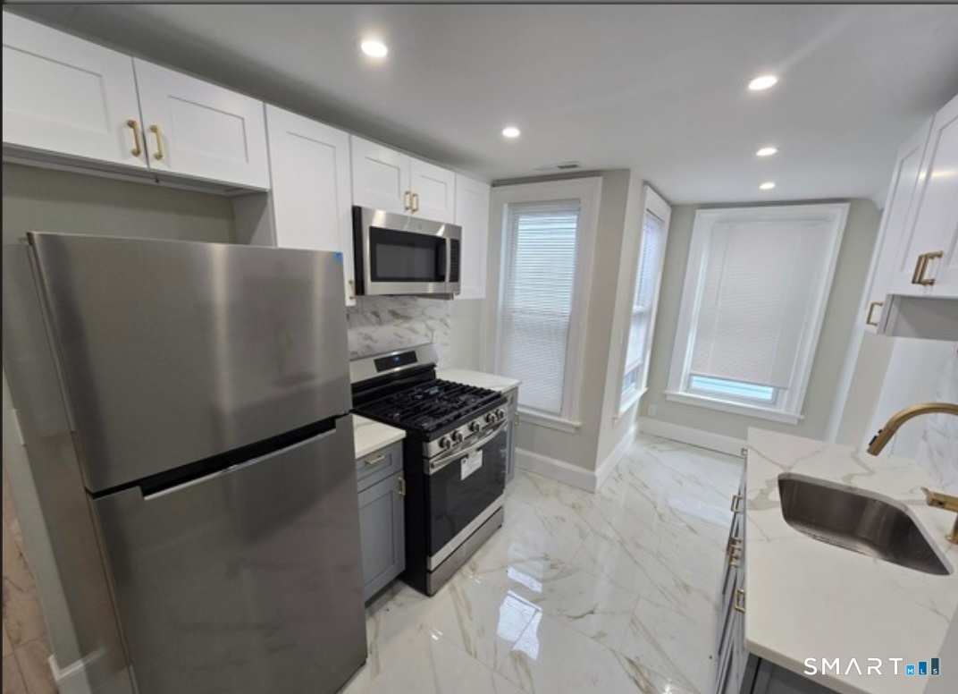 80 Dickerman Street New Haven, CT 06511 - Photo 2 of 12 a kitchen with stainless steel appliances a refrigerator stove microwave and sink