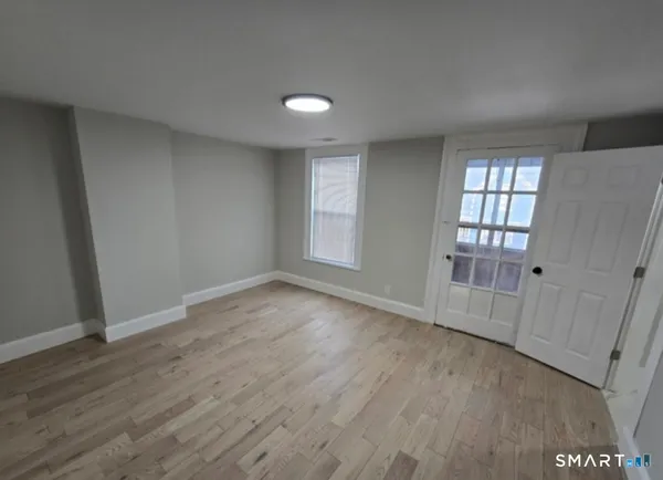 an empty room with wooden floor and windows
