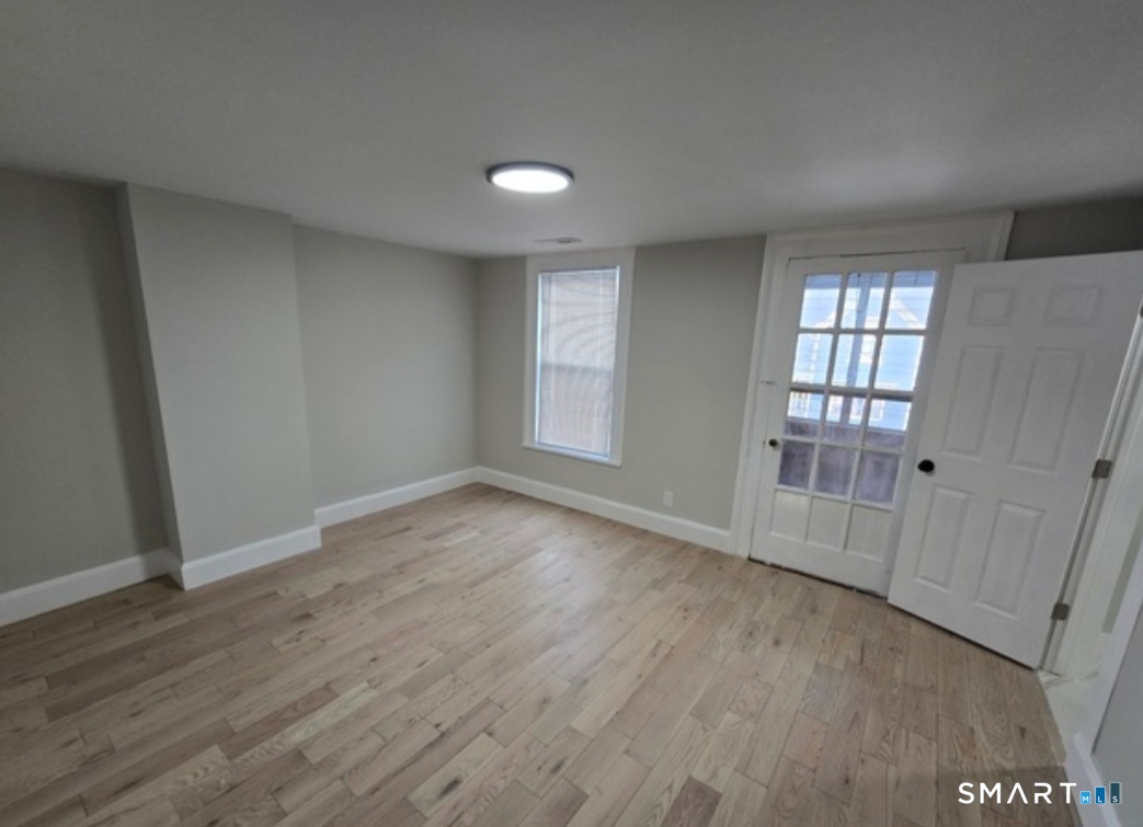 80 Dickerman Street New Haven, CT 06511 - Photo 3 of 12 an empty room with wooden floor and windows