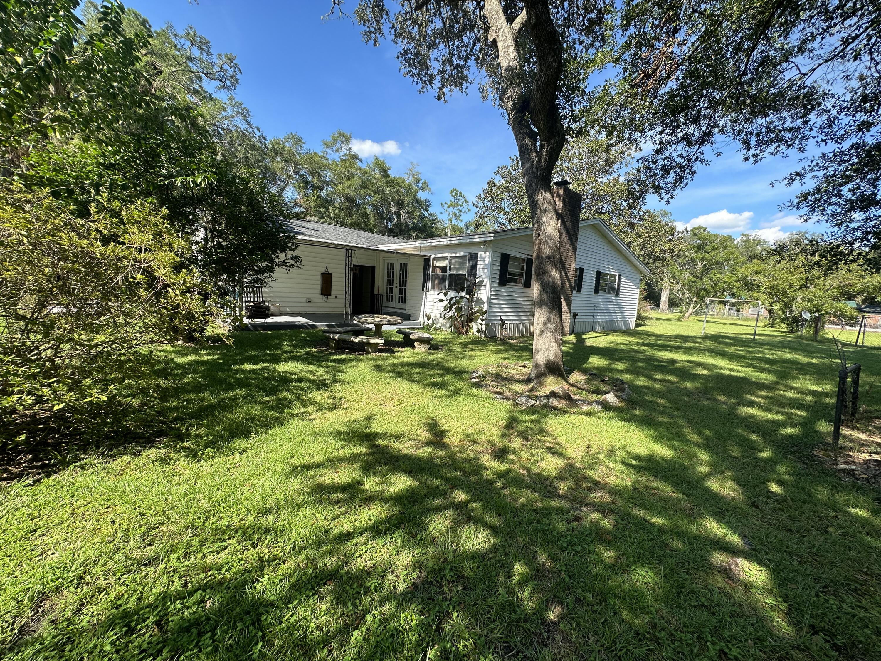 1875 Hathaway Johnson Road Baker, FL 32531 - Photo 28 of 40 a backyard of a house with yard and outdoor seating
