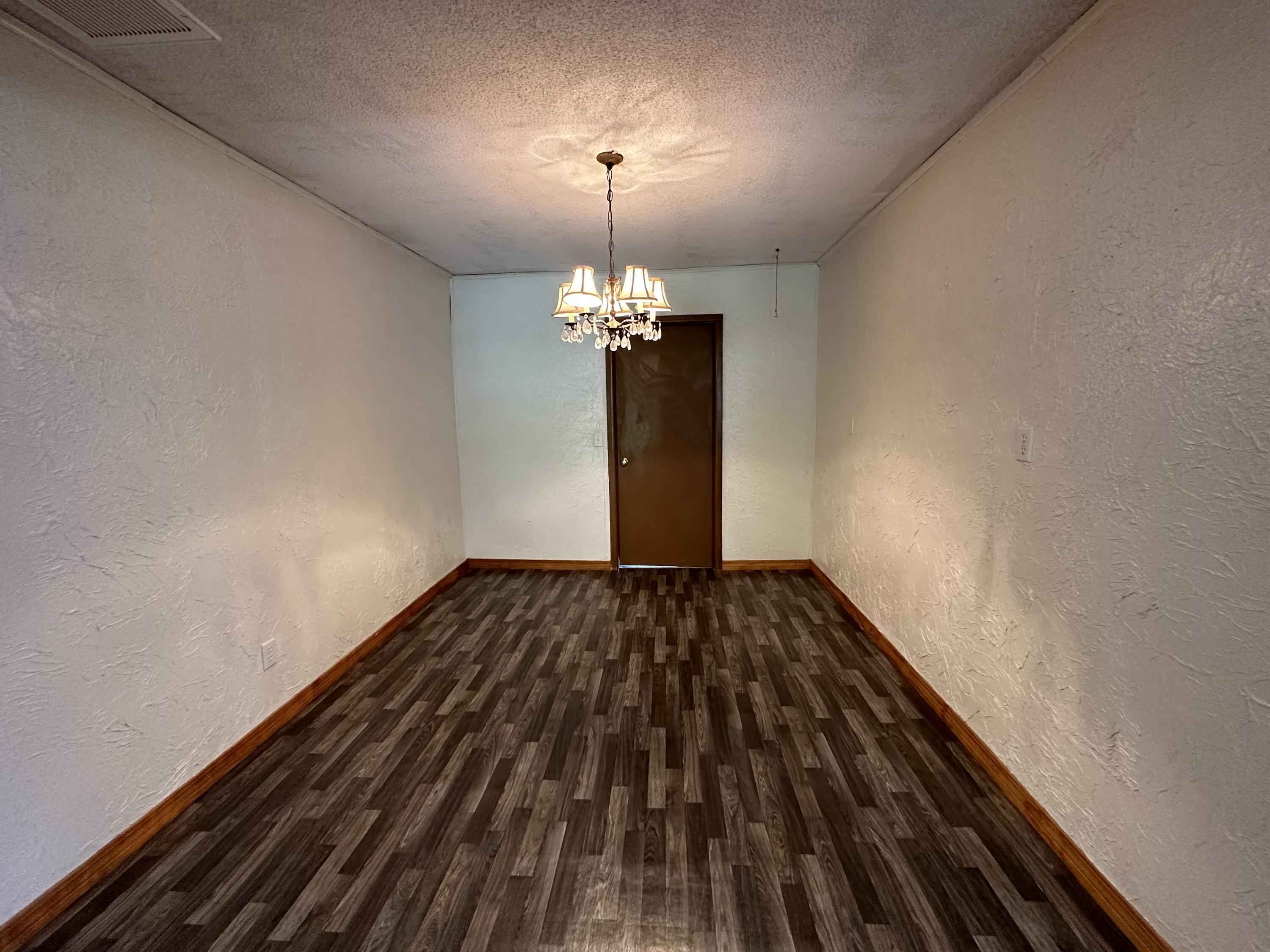 1875 Hathaway Johnson Road Baker, FL 32531 - Photo 6 of 40 a view of a livingroom with a chandelier and wooden floor