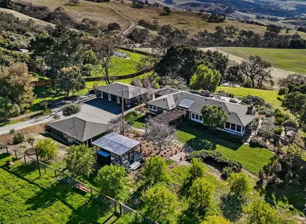 an aerial view of a house with a garden and lake view