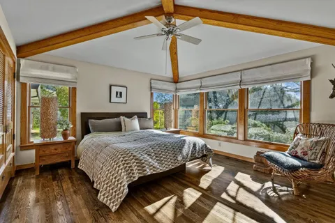 a bedroom with a bed and a large window