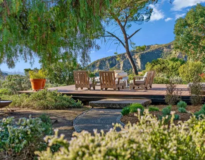 a view of deck with seating space and trees in the background