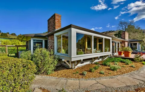 a front view of a house with yard porch and outdoor seating