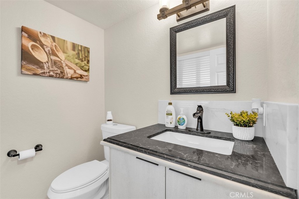 5056 Windhill Drive Riverside, CA 92507 - Photo 37 of 66 a bathroom with a toilet a sink and mirror