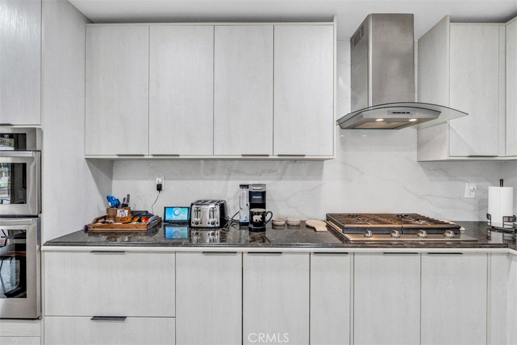 5056 Windhill Drive Riverside, CA 92507 - Photo 46 of 66 a kitchen with stainless steel appliances granite countertop white cabinets a sink and dishwasher