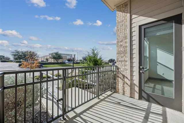 a view of a balcony with a floor to ceiling window and wooden floor
