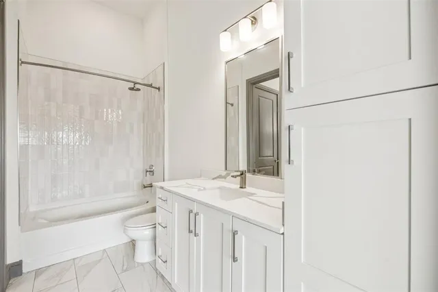 a bathroom with a sink a toilet a mirror and shower