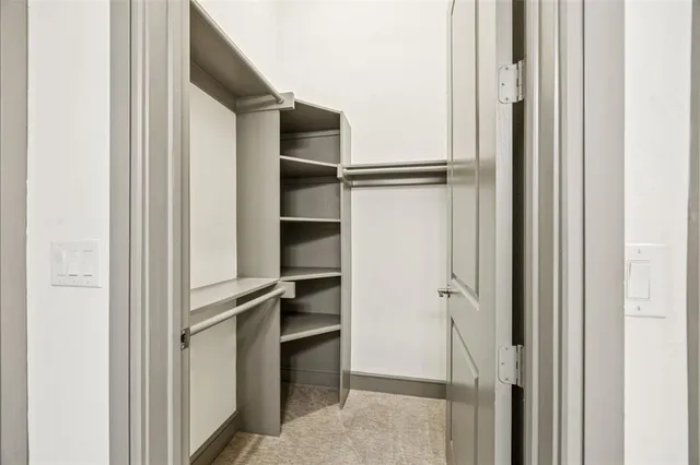 a view of walk in closet with empty racks