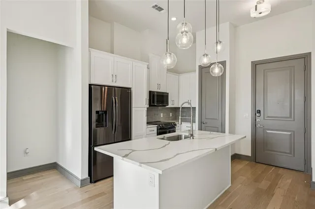 a kitchen with stainless steel appliances a refrigerator and a stove top oven