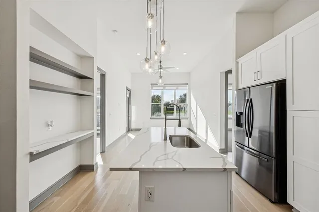 a kitchen with kitchen island a counter top space wooden floor and stainless steel appliances