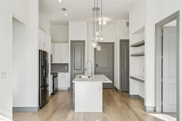 a bathroom with a sink a faucet a refrigerator and a mirror