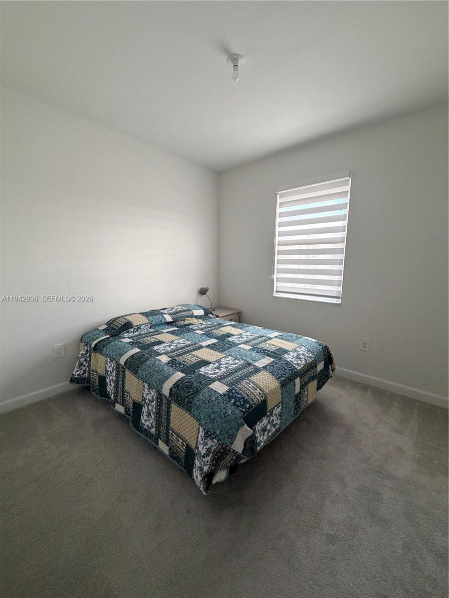 14872 Southwest 265th Street Homestead, FL 33032 - Photo 13 of 15 a bed sitting in a bedroom next to a window