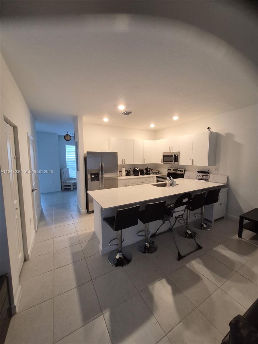 14872 Southwest 265th Street Homestead, FL 33032 - Photo 6 of 15 a living room with chairs furniture and kitchen view