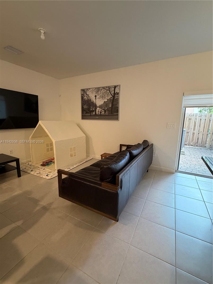 14872 Southwest 265th Street Homestead, FL 33032 - Photo 8 of 15 a living room with furniture and a flat screen tv