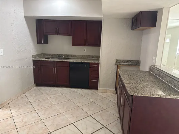 a kitchen with granite countertop a sink and a stove