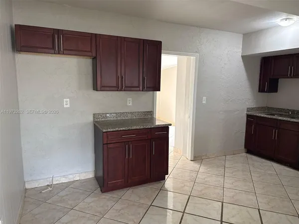 a kitchen with a refrigerator and a stove top oven
