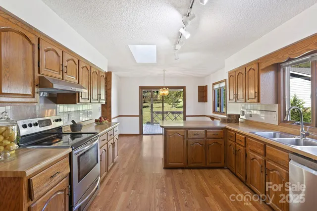 a kitchen with stainless steel appliances a stove sink and cabinets