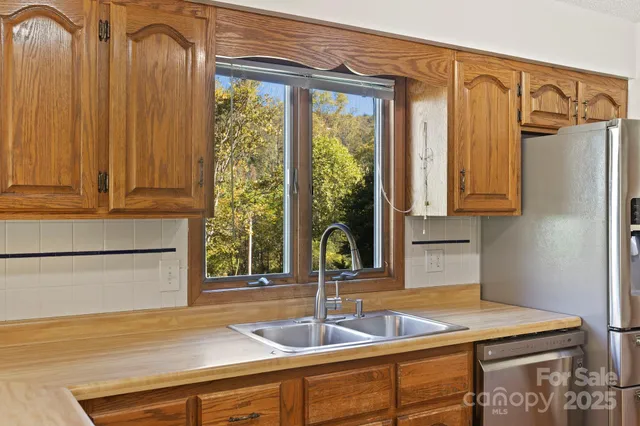 a kitchen with sink a refrigerator and window