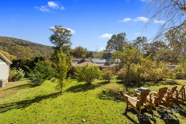 an aerial view of a house with swimming pool and large trees