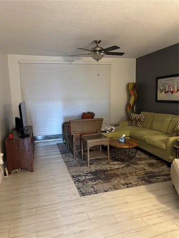 a living room with furniture a flat screen tv and kitchen view