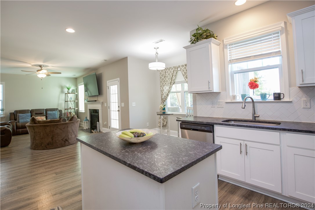 474 Kerr Lake Road Aberdeen, NC 28315 - Photo 16 of 47 a kitchen with sink a stove and chairs