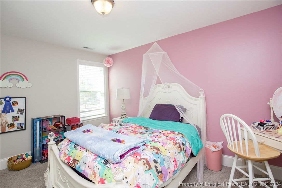 474 Kerr Lake Road Aberdeen, NC 28315 - Photo 26 of 47 a bedroom with a bed and a chandelier