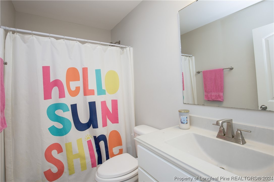 474 Kerr Lake Road Aberdeen, NC 28315 - Photo 28 of 47 a bathroom with a sink mirror vanity and toilet