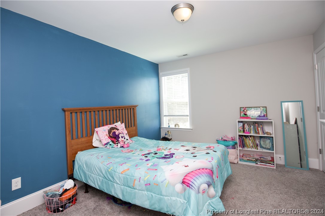 474 Kerr Lake Road Aberdeen, NC 28315 - Photo 29 of 47 a bedroom with a bed and a book shelf