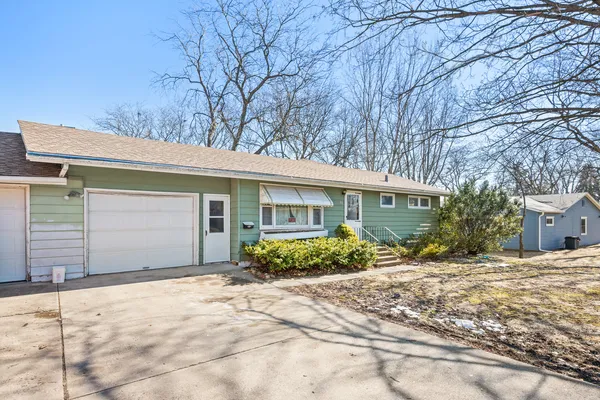a front view of a house with a yard and potted plants