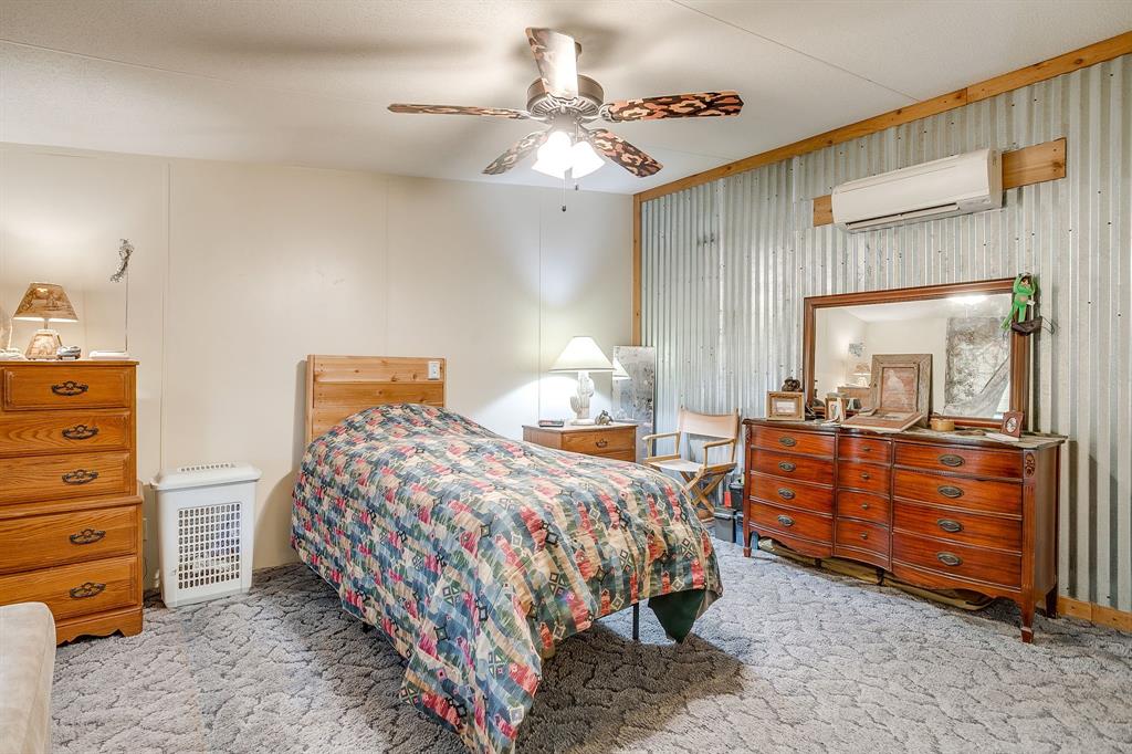 436 Luke Road Springtown, TX 76082 - Photo 23 of 39 Bedroom featuring carpet flooring, a wall mounted AC, a ceiling fan, and radiator heating unit