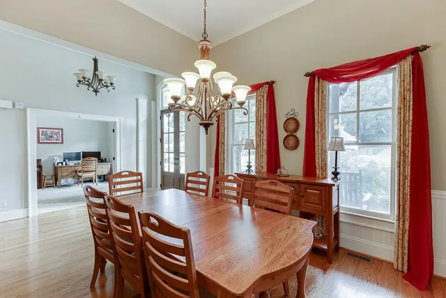 a kitchen with stainless steel appliances a dining table chairs stove and refrigerator