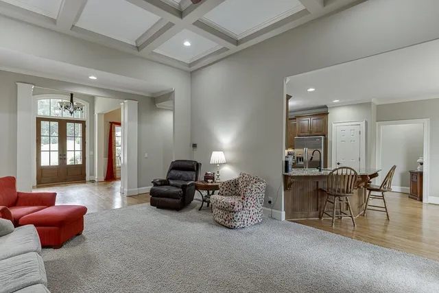 a kitchen with stainless steel appliances granite countertop a refrigerator a sink dishwasher a stove and a refrigerator with wooden floor