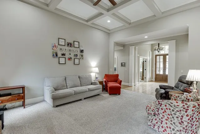 a bedroom with a bed a dresser and a large window