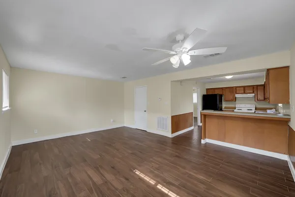 a view of a kitchen with wooden floor and a ceiling fan
