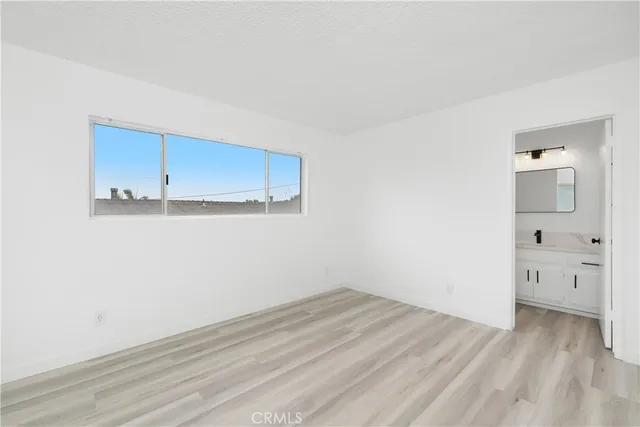 an empty room with a fireplace and wooden floor