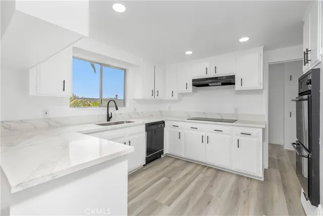 a kitchen with a sink window and stainless steel appliances