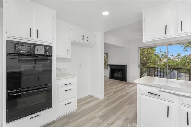 a kitchen with stainless steel appliances a stove and white cabinets