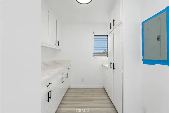 a hallway with white cabinets and white appliances