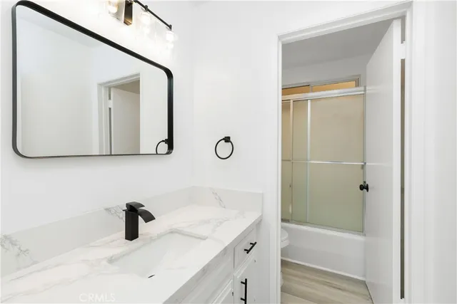 a bathroom with a tub sink and mirror