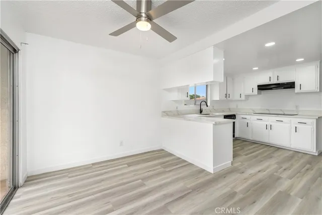 a kitchen with a sink cabinets and wooden floor