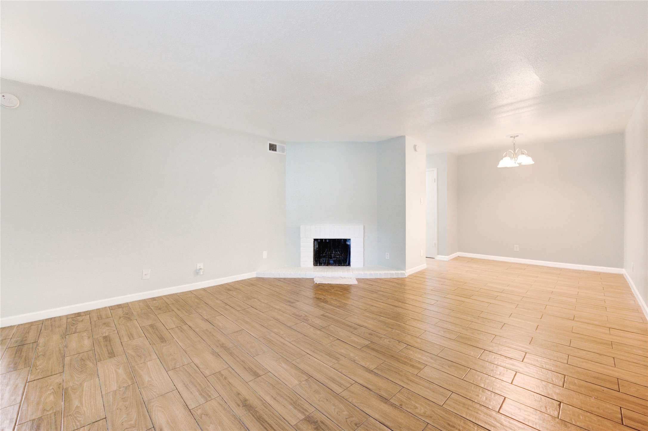 6200 West Tidwell Road, Unit 2608 Houston, TX 77092 - Photo 11 of 17 a view of an empty room with wooden floor and a fireplace