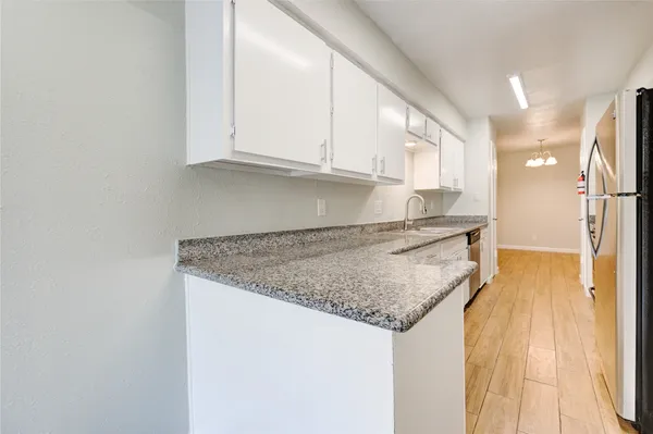 a kitchen with granite countertop a sink and cabinets
