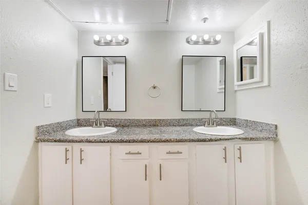 a bathroom with double vanity sinks and a mirror