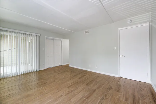 a view of an empty room with wooden floor