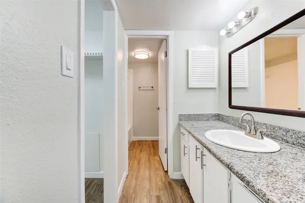 a en suite bathroom with a granite countertop sink and a mirror